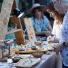 Shoppers browse handcrafted jewelry at an outdoor artisan market stall.