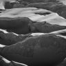 Captivating black and white photo of Saas Fee's snowy mountain formations.